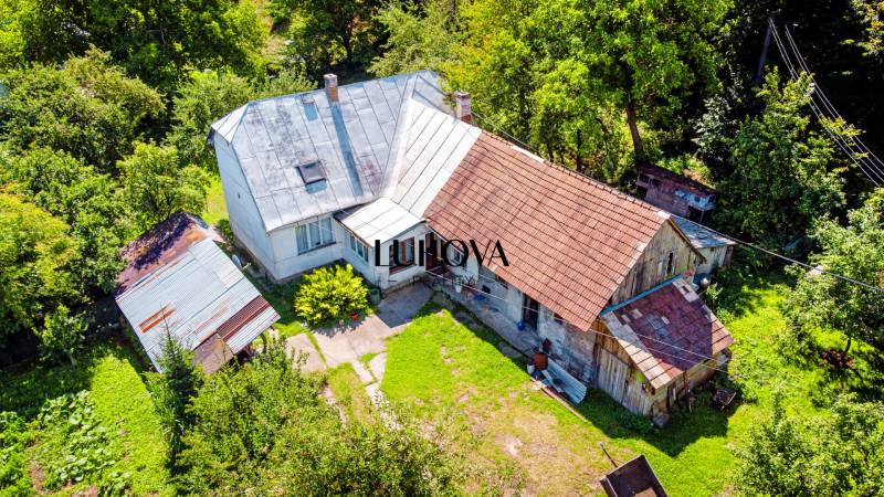 Rodinný dom na rekonštrukciu_Lúky - Rodinný dom s plechovou strechou v Lúkach na ulici Lúky obklopený zeleňou.