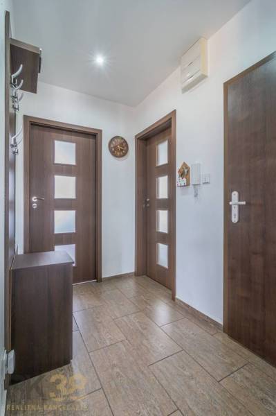  Na predaj kompletne zrekonštruovaný 3-izbový byt s balkónom v Poprade - Chodba v 3-izbovom byte, obsahuje dvere, vešiak a hodiny.