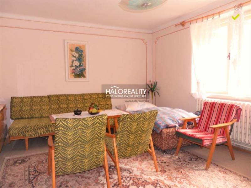 REZERVOVANÉ - Predaj, rodinný dom Trebatice - Obývacia izba v rodinnom dome, vintage nábytok, koberec, svetlé steny, veľké okno.