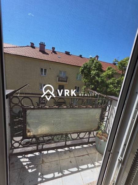 *REZERVOVANÉ* 2 IZBOVÝ TEHLOVÝ BYT, KOŠICE - JUH - Balkón 2-izbového bytu s výhľadom na susednú budovu a strechy, Košice - mestská časť Juh, Pasteurovo námestie.