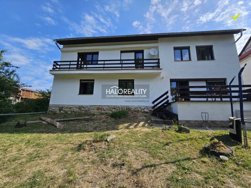Predaj, rodinný dom Banská Štiavnica - EXKLUZÍVNE HA... - Rodinný dom v Banskej Štiavnici s dreveným balkónom na svahu a trávnatým pozemkom.