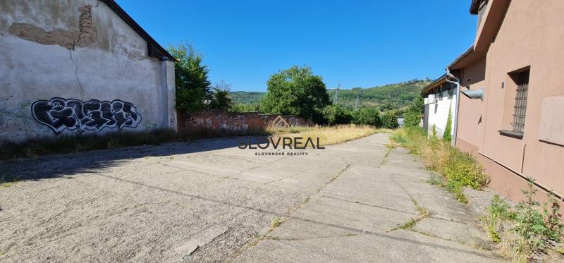 SLOVREAL predaj pozemku Žiar nad Hronom - Plocha s betónovou dlažbou medzi budovami, vhodná na pozemky - bývanie v Žiari nad Hronom.