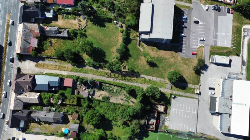 SLOVREAL predaj pozemku Žiar nad Hronom - Letecký pohľad na pozemky pre bývanie v Žiari nad Hronom s cestou a parkovaním.