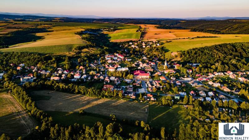  Objavte investičný potenciál bytového domu  v Dolnej Strehovej  - Letecký pohľad na dedinu Dolná Strehová obklopenú prírodou a poľami.