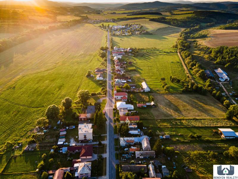  Objavte investičný potenciál bytového domu  v Dolnej Strehovej  - Vidiecka krajina s domami a cestou pri západe slnka, Dolná Strehová, Hlavná ulica.