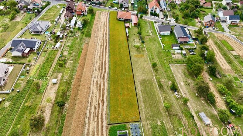Na predaj investičný stavebný pozemok pre 3 RD, Trenč.Jastrabie - Letecký pohľad ukazuje pozemky na bývanie v Trenčianskom Jastrabí obklopené domami a záhradami.