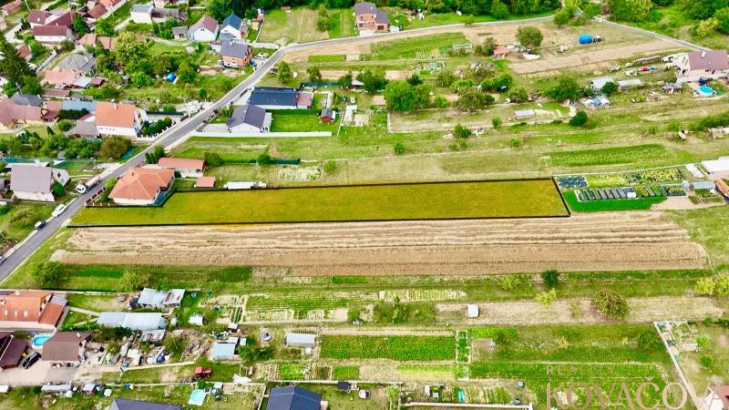 Na predaj investičný stavebný pozemok pre 3 RD, Trenč.Jastrabie - Panoramatický pohľad na pozemky na bývanie v Trenčianskom Jastrabí obklopené domami.