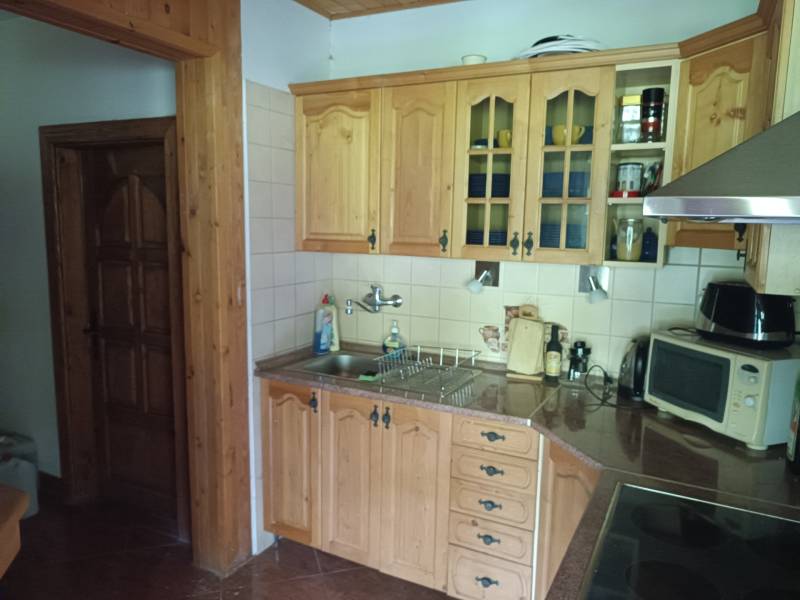 Na predaj chata pri jazere v Sklených Tepliciach - Kuchyňa na ulici Sklené Teplice, drevené skrinky, chata, mikrovlnka, domáci spotrebič, drez.