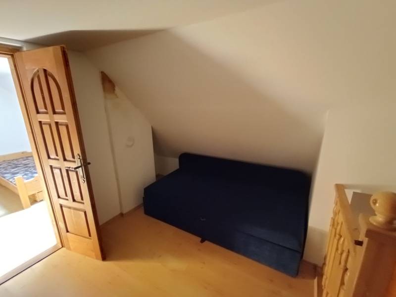 Na predaj chata pri jazere v Sklených Tepliciach - Izba s modrým gaučom, drevenými dverami na ulici Sklené Teplice a Chata.