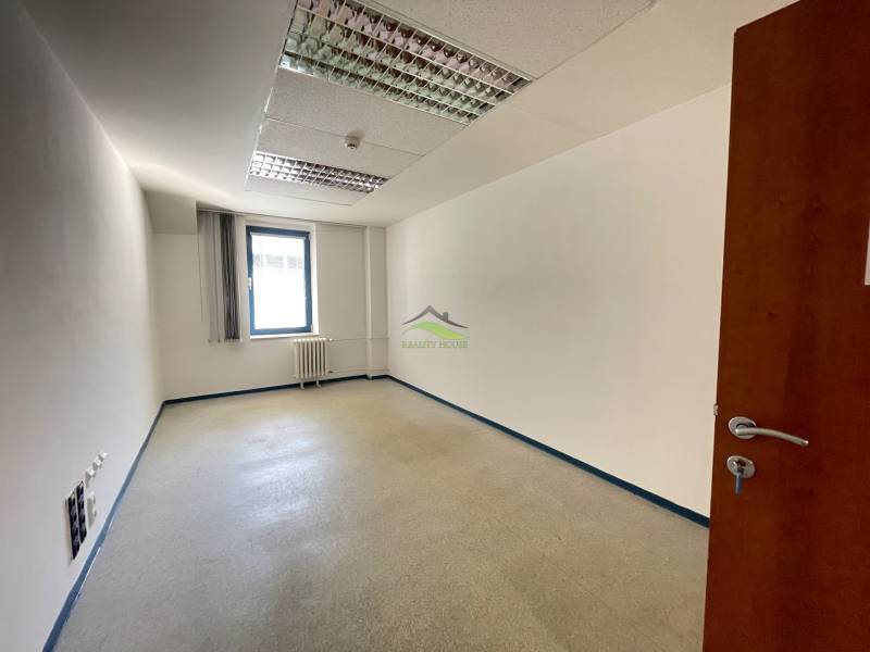 Zrekonštruované Kancelárie v centre mesta - na prízemí, aj na poschodí - Prázdna kancelária s bielymi stenami a oknom.