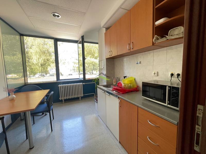 Zrekonštruované Kancelárie v centre mesta - na prízemí, aj na poschodí - Kuchynka v kancelárii so stolom, mikrovlnkou a veľkými oknami.