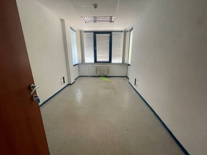 Zrekonštruované Kancelárie v centre mesta - na prízemí, aj na poschodí - Prázdna miestnosť s bielymi stenami a oknom v kancelárii.