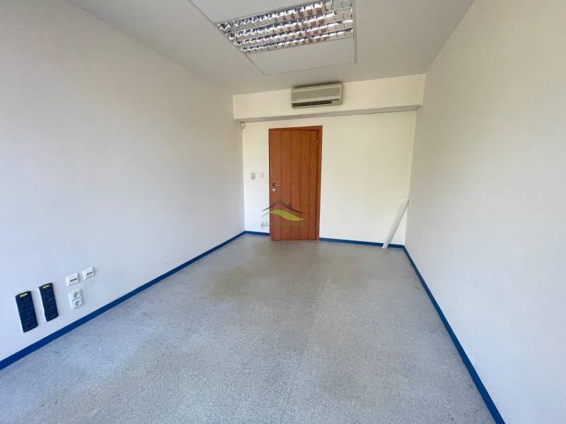 Zrekonštruované Kancelárie v centre mesta - na prízemí, aj na poschodí - Prázdna kancelária s drevenými dverami, klimatizáciou a podlahou v svetlých odtieňoch.