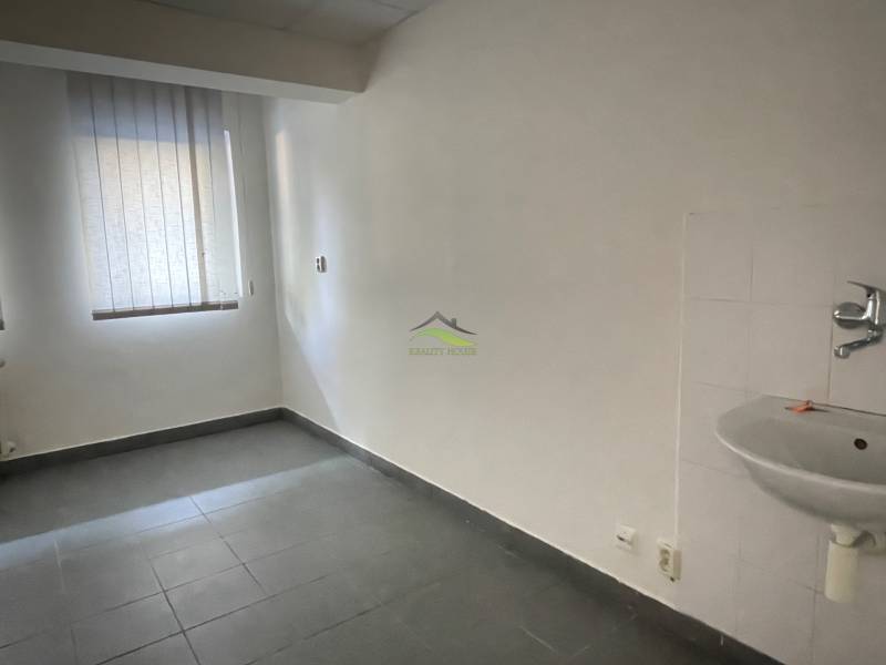 Zrekonštruované Kancelárie v centre mesta - na prízemí, aj na poschodí - Miestnosť v Kancelárii s podlahou z dlaždíc, okno so žalúziou a umývadlo.