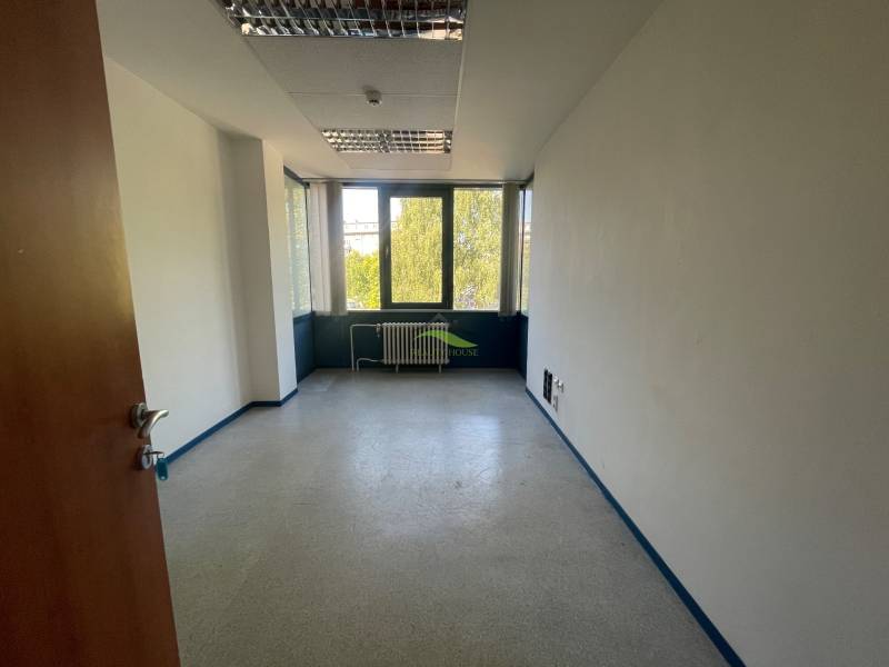Zrekonštruované Kancelárie v centre mesta - na prízemí, aj na poschodí - Miestnosť kancelárie s neutrálnym interiérom, veľké okná, radiátor pod oknom.