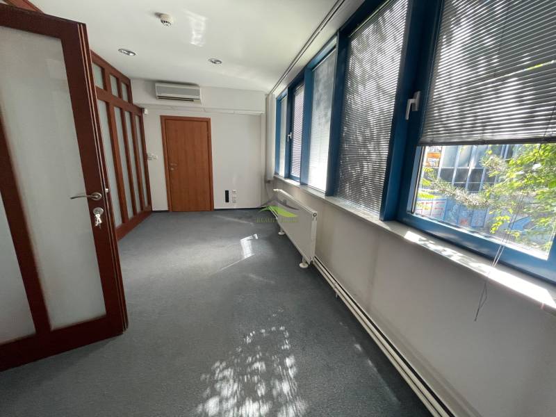 Zrekonštruované Kancelárie v centre mesta - na prízemí, aj na poschodí - Kancelária s dverami a veľkými oknami so žalúziami, miestnosť je presvetlená.