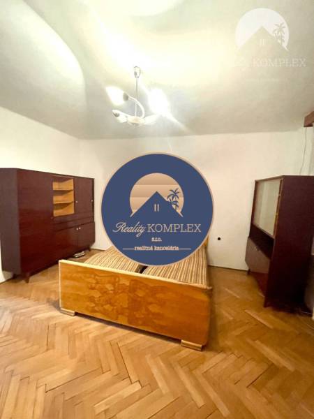 Vám ponúka Rodinný dom vo Veľkom Blahove - s ve - Spálňa v rodinnom dome so starším nábytkom a drevenou podlahou.