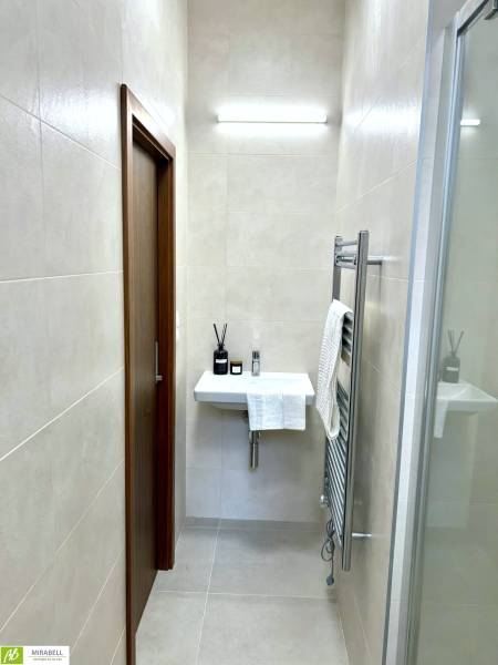 POSLEDNÝ Nový 2 izbový byt s klimatizáciou v projekte Gunduličova - Kúpeľňa s umývadlom a osvetlením v 2-izbovom byte, s minimalistickým dizajnom.