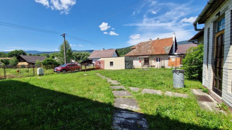 AstonReal: predaj rodinný dom v obci Mníšek nad Hnilcom - Rodinný dom v Mníšku nad Hnilcom s trávnikom, terasou a parkoviskom pod jasnou oblohou.