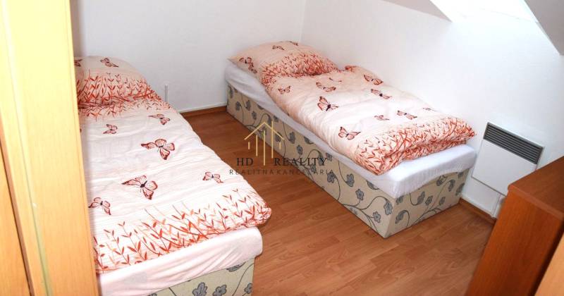 PREDAJ, Mezonetový apartmán v apartmánovom dome Horec, Donovaly - Detská izba v 3-izbovom byte s dvoma lôžkami a jednoduchou drevenou podlahou.