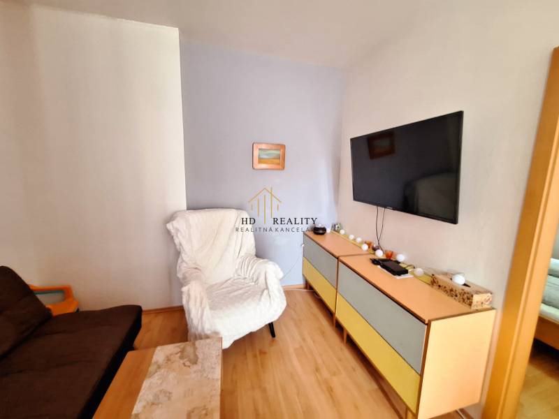PREDAJ, Mezonetový apartmán v apartmánovom dome Horec, Donovaly - Obývacia izba v 3-izbovom byte, s TV na stene a pohodlnými kreslami.