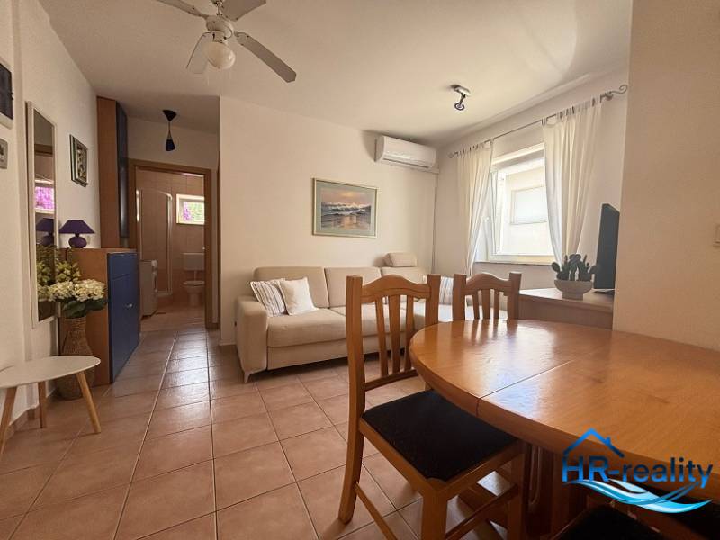☀NOVALJA (HR) -  2-izbový apartmán 45 m2 s terasou v 2.rade u mora - Obývacia izba v 2-izbovom byte s jedálenským stolom, pohovkou a klimatizáciou.