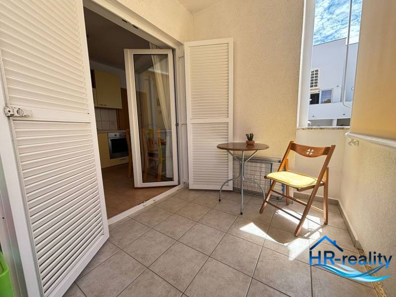 ☀NOVALJA (HR) -  2-izbový apartmán 45 m2 s terasou v 2.rade u mora - Balkón vo 2-izbovom byte s bielymi žalúziami a drevenou stoličkou.