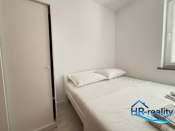 ☀NOVALJA (HR) - 3-izbový moderne zariadený apartmán, blízko pláže  - Svetlá spálňa s pohodlnou posteľou a bielou skriňou v 3-izbovom byte.