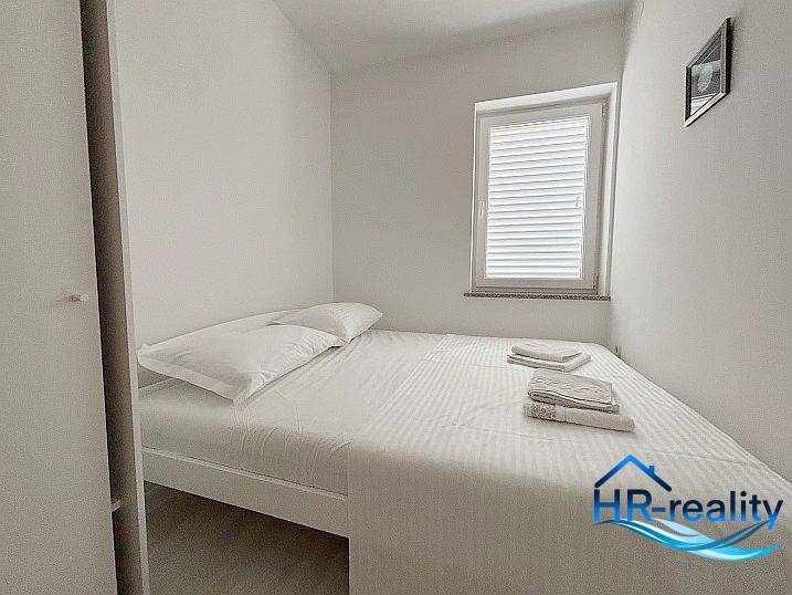☀NOVALJA (HR) - 3-izbový moderne zariadený apartmán, blízko pláže  - Svetlá spálňa s posteľou, oknom a bielou posteľnou bielizňou v 3-izbovom byte.
