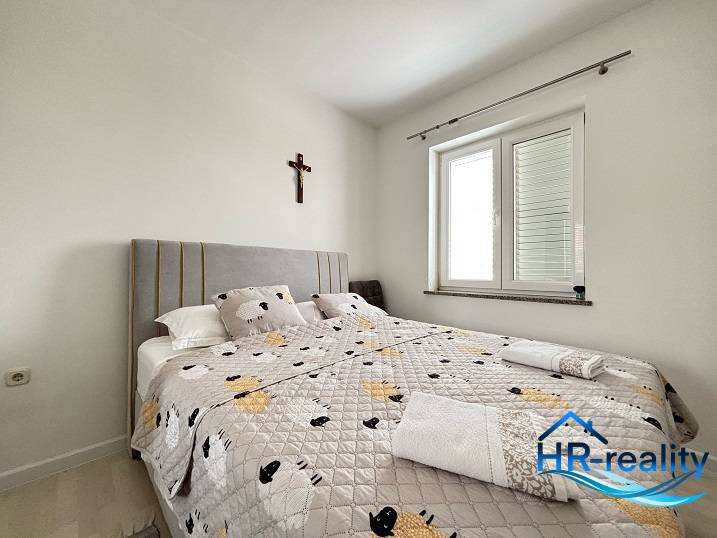 ☀NOVALJA (HR) - 3-izbový moderne zariadený apartmán, blízko pláže  - Svetlá spálňa s pohodlnou posteľou v 3-izbovom byte, kríž na stene.