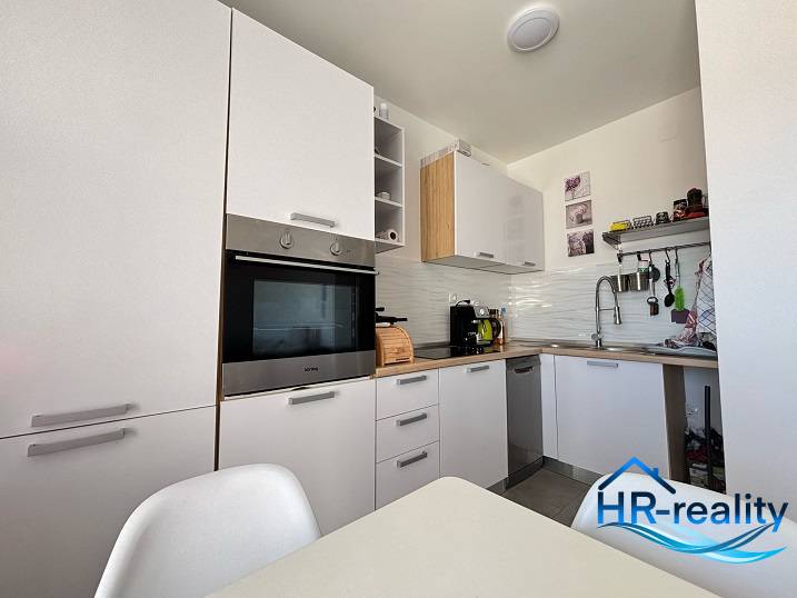 ☀NOVALJA (HR) - apartmán s pekným výhľadom na more  - Kuchyňa v 2-izbovom byte s modernými bielymi skrinkami a zabudovanými spotrebičmi.