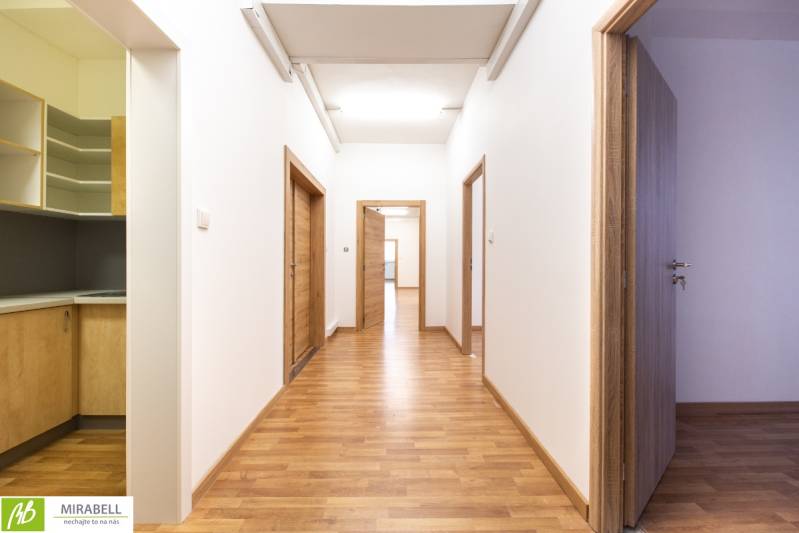 Klimatizované kancelárske priestory v areáli na Pestovateľskej ulici - Chodba s drevenou podlahou a dverami v kancelárii.