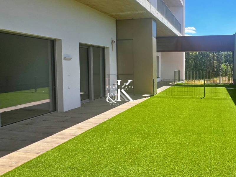 2 i  apartmán s predzáhradkou, šatníkmi, kobkou, Banka - Piešťany - Terasa s umelým trávnikom a posuvnými dverami Rekreačného apartmánu v Banke.