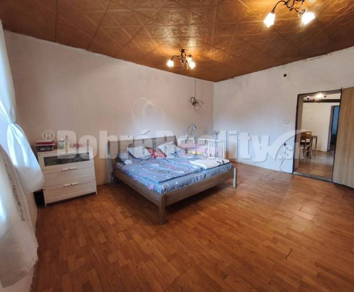 Rodinný dom v pôvodnom stave ,vhodný na rekonštrukciu....vo vyhľadávan - Spálňa v rodinnom dome s drevenou podlahou a dvojposteľou.