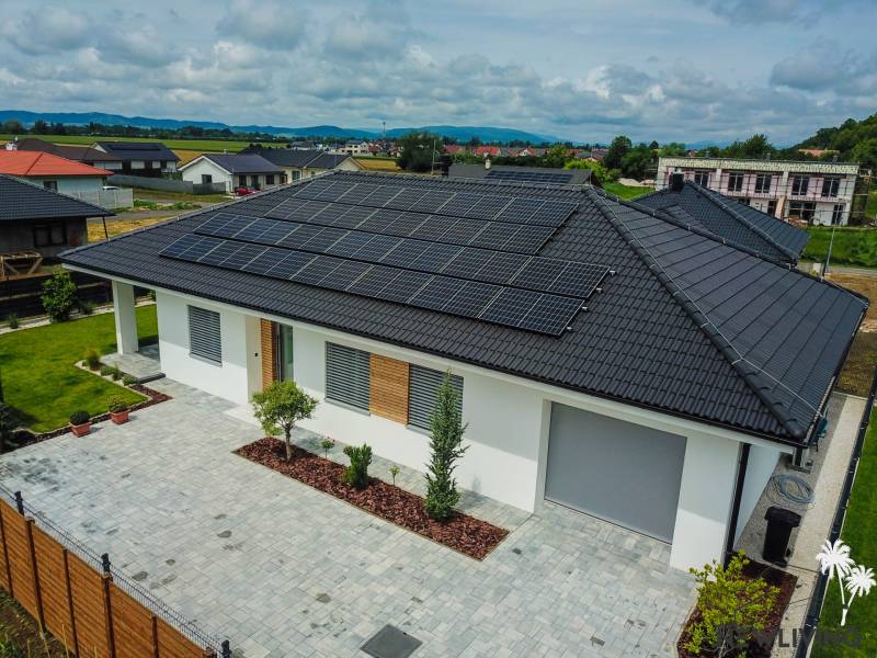 Predaj 4iz. novostavby RD s garážou na Modrovke 1km od diaľnice - Rodinný dom v Piešťanoch s fotovoltaickými panelmi na streche obklopuje zelená záhrada.