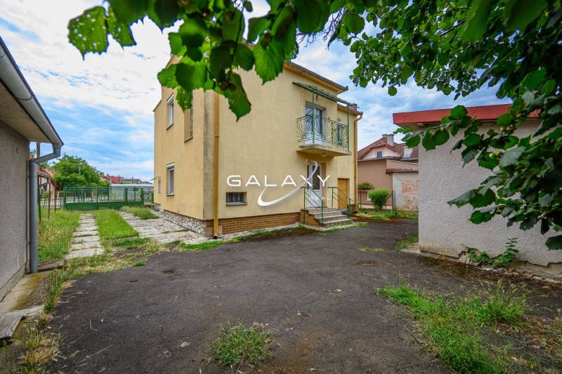 Rodinný dom s veľkým pozemkom na predaj – Vidiná, okres Lučenec - Rodinný dom vo Vidinej so záhradou, trávnikom a okolitými stavbami.