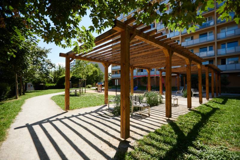 NOVOREKONŠTRUOVANÝ 2 - IZBOVÝ BYT , UL. LOMONOSOVOVA, TERASA - Drevená pergola s lavičkami v parku v Košiciach, mestská časť Juh, obklopená zeleňou.