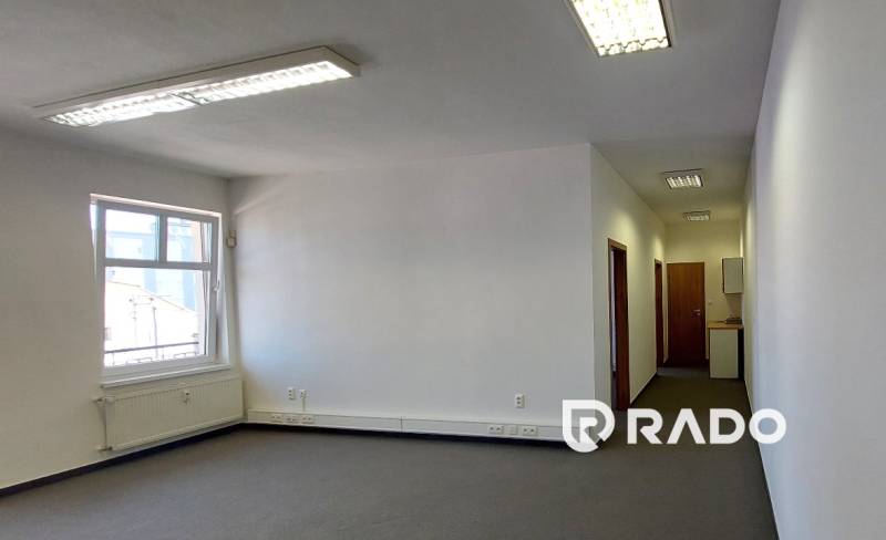 Prenájom kancelárie 70 m2 - Nám. sv. Anny, Trenčín - Priestranné kancelárie s oknom a chodbou, svetlé steny, neutrálny koberec.