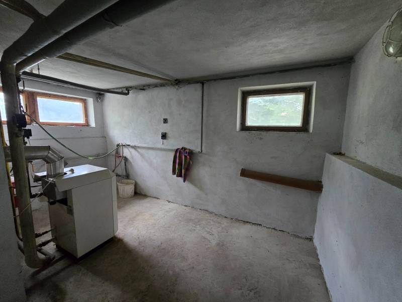 Veľký 6 izbový rodinný dom - Rakoľuby - Kotolňa v rodinnom dome s kotlom, potrubím a malými oknami.
