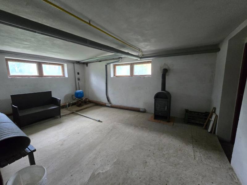 Veľký 6 izbový rodinný dom - Rakoľuby - Pivničná miestnosť v rodinnom dome s pecou a jednoduchým zariadením.
