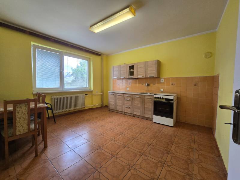 Veľký 6 izbový rodinný dom - Rakoľuby - Kuchyňa v rodinnom dome so žltými stenami, dreveným nábytkom a keramickou dlažbou.