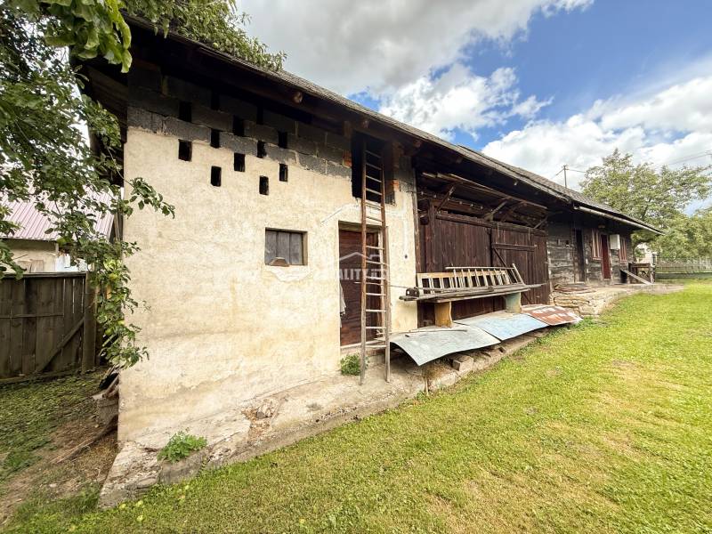 Exkluzívne na predaj drevenica s pozemkom 406 m2, Papradno - Pohľad na staršiu chatu v Papradne s drevenou konštrukciou a upraveným dvorom.