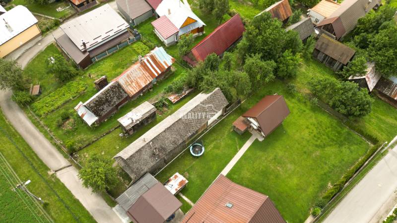 Exkluzívne na predaj drevenica s pozemkom 406 m2, Papradno - Letecký pohľad na dedinské chaty obklopené zeleňou v Papradne.