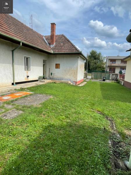 Ponúkame na predaj starší rodinný domček v Trenčianskych Stankovciach - Rodinný dom v Trenčianskych Stankovciach s udržiavaným trávnikom a tradičnou šikmou strechou.