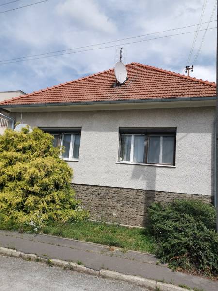 5 izbový rodinný dom Topoľčianky - Rodinný dom v Topoľčiankach so sedlovou strechou a satelitnou anténou.