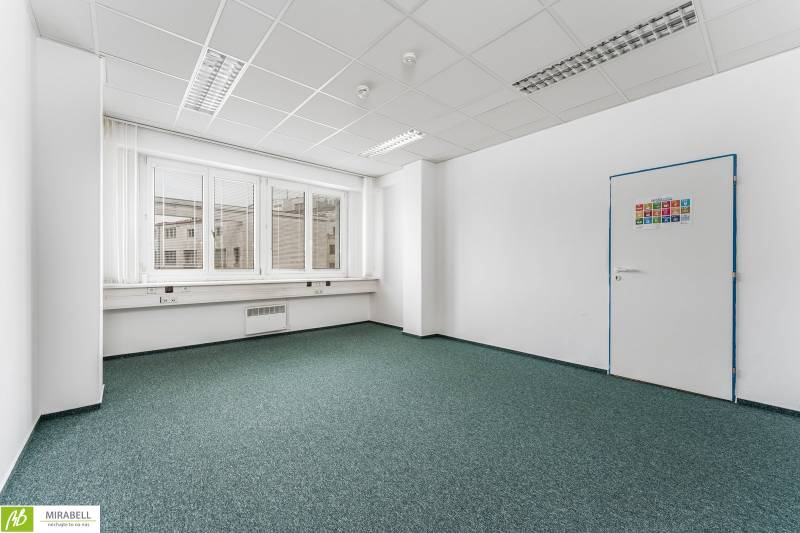 Klimatizované kancelárie v centre mesta na Štúrovej ulici  - Prázdna kancelária s koberecom a oknami, biele steny, zelený koberec.