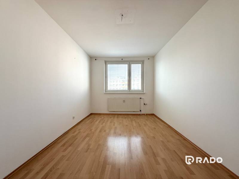 Priestranný 3-izbový byt s balkónom 68 m² Belinského - Prázdna svetlá miestnosť s laminátovou podlahou v 3-izbovom byte.