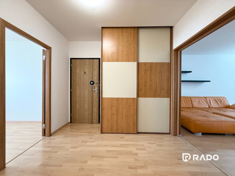 Priestranný 3-izbový byt s balkónom 68 m² Belinského - Interiér 3-izbového bytu s drevenými prvkami a svetlou podlahou.
