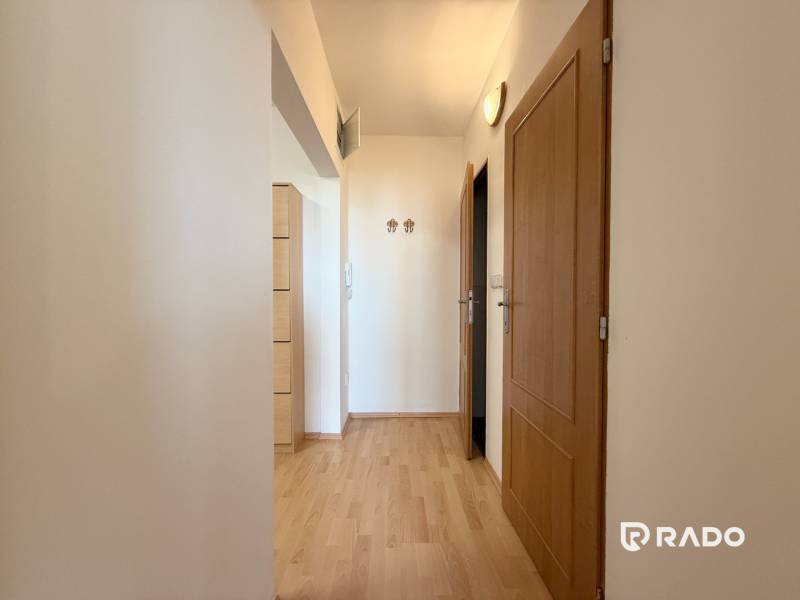 Priestranný 3-izbový byt s balkónom 68 m² Belinského - Chodba s drevenou podlahou a dvermi v 3-izbovom byte.