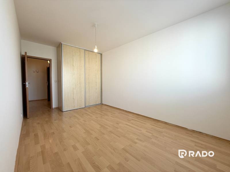Priestranný 3-izbový byt s balkónom 68 m² Belinského - Priestranná izba s drevenou podlahou a vstavanou skriňou v 3-izbovom byte.